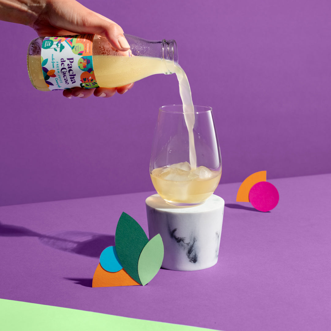 Someone poring Pacha de Cacao juice into a glass showing the pureness of the juice
